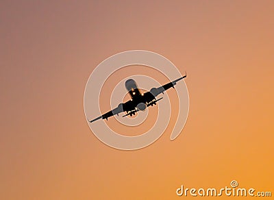 Silhouette of a landing aircraft at sunset Stock Photo