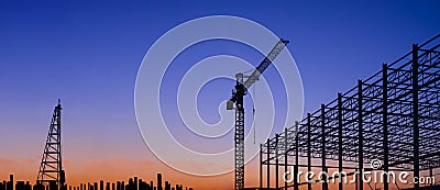Silhouette of large industrial building structure with pile driver and crane in construction site at sunset Editorial Stock Photo