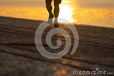 Silhouette of legs athlete running at the sunrise on river coast Stock Photo