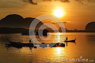 Silhouette Lifestyle Fisherman On Boat Fishing in Morning Golden Stock Photo