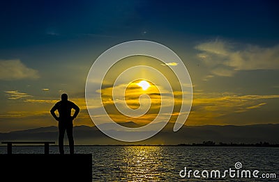 Silhouette,lonely man watching the sea at sunset Stock Photo