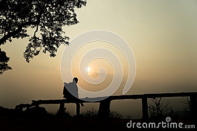 Silhouette lonely men watching the sunset among the mountains. Stock Photo