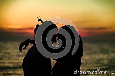 Silhouette of Lovely Couple at the beach Stock Photo