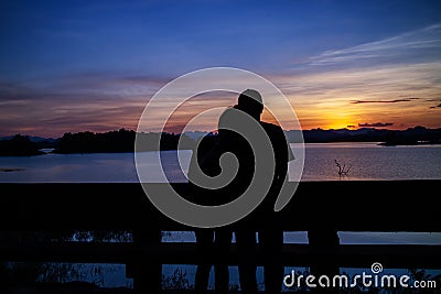 Silhouette of lovely couple on lake Stock Photo