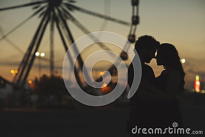 Silhouette of a loving couple in the evening. Behind them are the wheel of inspection Editorial Stock Photo