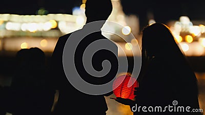 Silhouette loving couple at festival of floating Lanterns near river at night Stock Photo