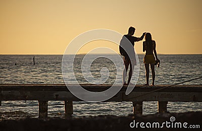 Silhouette Loving couple by the sea at sunset Stock Photo