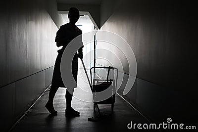 Silhouette of maid cleaning floor Stock Photo