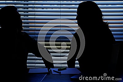 Silhouette of male and female coworkers flirting in office Stock Photo