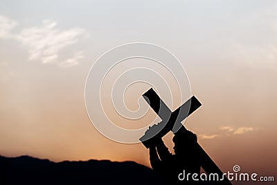Silhouette of a man carrying a cross at sunset. concept of religion Stock Photo