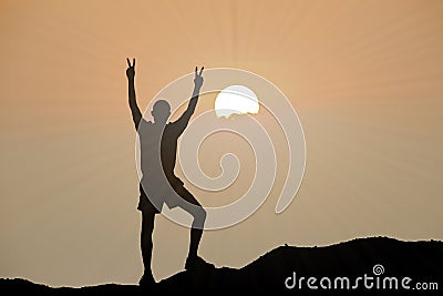 Silhouette of man is climbing to peak of hill Stock Photo