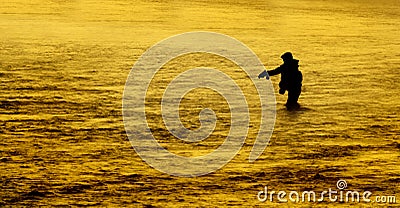 Silhouette of Man Flyfishing Fishing in River Golden Sunlight Fast Water Pole Stock Photo