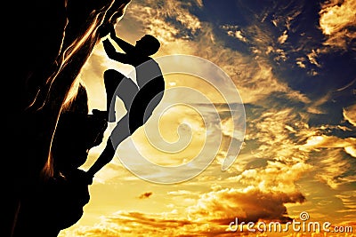 A silhouette of man free climbing on mountain Stock Photo