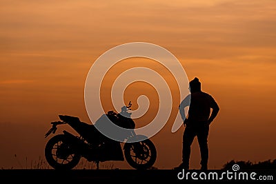 Silhouette man and his motorcycle To live a lifestyle. Stock Photo