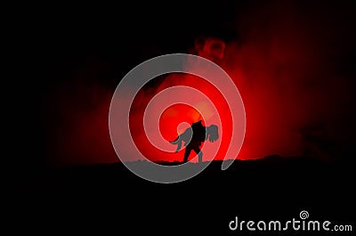 a silhouette of a man holding on to the woman. Rescue saviour concept. Escape from fire or danger. Hourglass, Fire Stock Photo