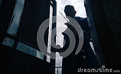Silhouette of man in image of black magician with magic wand in his hand Stock Photo