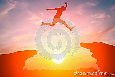 Silhouette of man jump over the cliff Stock Photo
