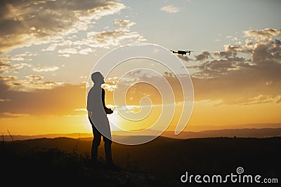 Man piloting a drone during the sunrise Stock Photo