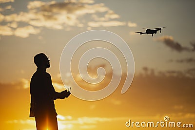 Man piloting a drone during the sunrise Stock Photo