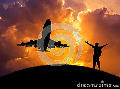 Silhouette the man raised up arms achievements successful and celebrate during airplane flying in sunset Stock Photo