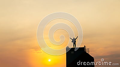 Silhouette of man on rofftop over sky and sun light background,business, success, leadership, achievement and people concept Stock Photo