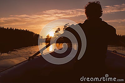 Silhouette of man rowing in sunset Stock Photo