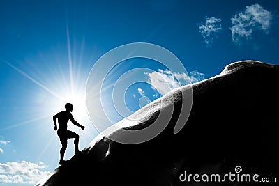 Silhouette of a man running up hill to the peak of the mountain Stock Photo