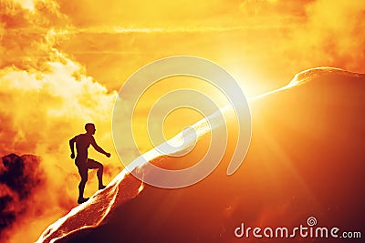 Silhouette of a man running up hill to the peak of the mountain Stock Photo