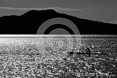 Silhouette of a man sea kayaking Stock Photo