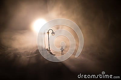 The silhouette of a man in shorts, standing in the middle of the road on a misty night. The glare of the street light against the Stock Photo