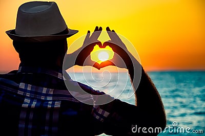 Silhouette of a Man showing love with fingers Stock Photo