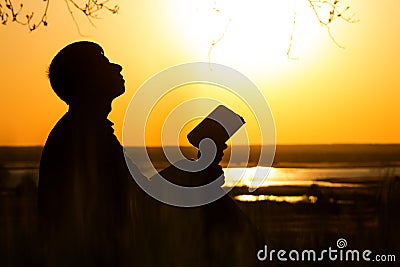 Silhouette of man turning to God with hope, the concept of faith and spirituality Stock Photo