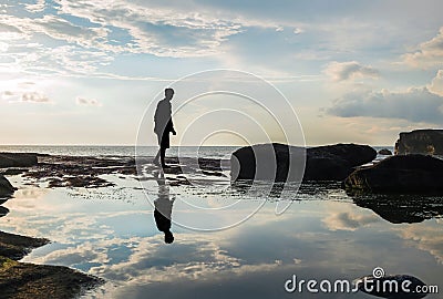 Silhouette, a man walking with reflection on water Stock Photo