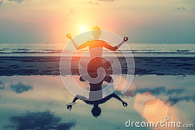 Silhouette meditation girl on the background of the stunning sea and sunset. Stock Photo