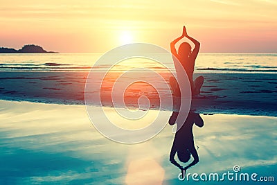 Silhouette meditation girl on the background of the stunning sea and sunset Stock Photo