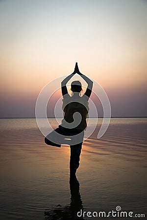 Silhouette meditation girl on the background of the stunning sea Stock Photo