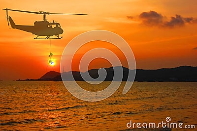 Silhouette military helicopter drop soldier on marine duty with sunset beauty sky abstract nature background Stock Photo