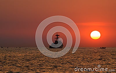 Silhouette military war ship and the sun Editorial Stock Photo