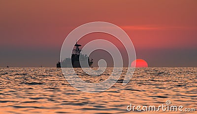 Silhouette military war ship and the sun Editorial Stock Photo