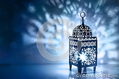 Silhouette of Moroccan lantern with burning glowing candle. Decorative shadows. Festive greeting card, invitation for Stock Photo