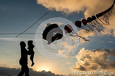 silhouette of mother and child playing kites Stock Photo