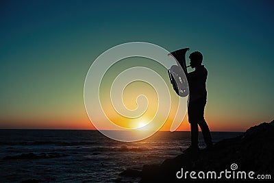 Silhouette of musician with tuba on the beach Stock Photo