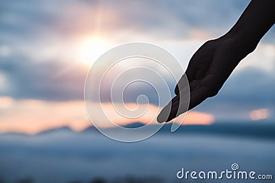 Silhouette off Human reaching hand with palm ups on sunrise ba Stock Photo