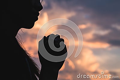 Silhouette off young woman praying for God`s blessings with th Stock Photo