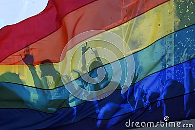 silhouette of a parade of gays and lesbians with a rainbow flag - symbol of love and tolerance Stock Photo