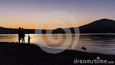 Silhouette of Family at a Lake Stock Photo