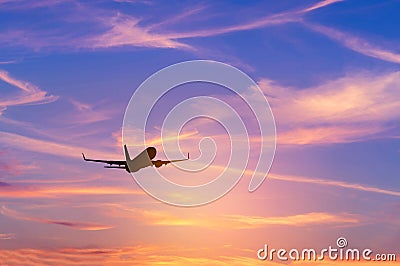 Silhouette passenger airplane flying away in to sky high altitude during sunset time Stock Photo