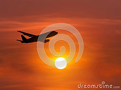 Silhouette passenger airplane flying away in to sky on sunset Stock Photo