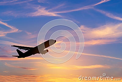 Silhouette passenger airplane flying away in to sky during sunset Stock Photo