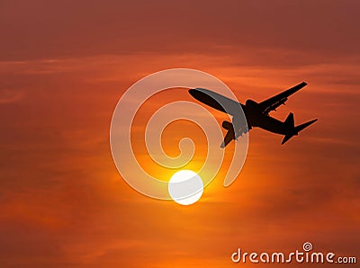 Silhouette passenger airplane flying on sunset Stock Photo
